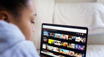 Eine junge Frau schaut Netflix auf ihrem Laptop.