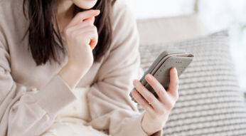 Eine Person hält ein Smartphone in der Hand und schaut auf den Bildschirm.