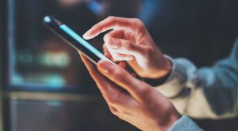 Die Hand einer Frau tippt auf ein Smartphone-Display