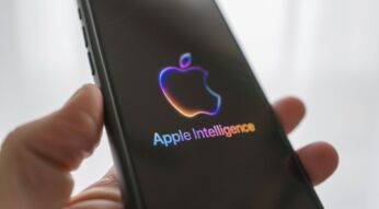 Eine Hand hält ein iPhone mit Apple-Logo und dem Text "Apple Intelligence".