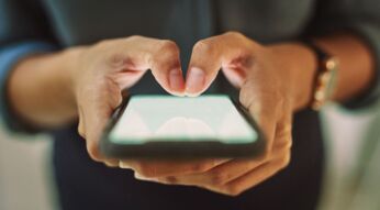 Zwei Hände tippen auf einem Smartphone-Display