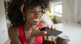 Eine Frau spricht in ihr Smartphone.