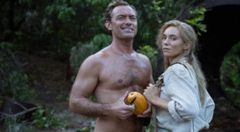 Jude Law als Philosoph Dr. Friedrich Ritter und seine Frau Dore Strauch stehen im Dschungel, während er eine Frucht in der Hand hält.