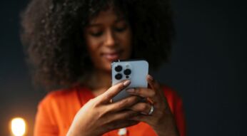 Schwarze Frau hält ein iPhone in den Händen.