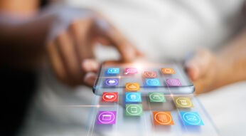 Eine Frau hält ein Smartphone in der Hand und wischt scheinbar App-Icons aus dem Gerät heraus.