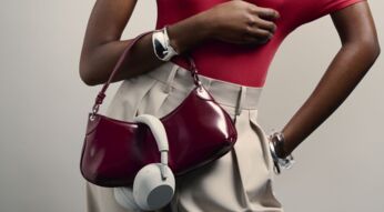 Frau trägt Sony-Kopfhörer über ihrer Handtasche.