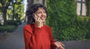 Kein Internet beim Telefonieren: Junge Frau steht im freien und telefoniert mit ihrem Smartphone.
