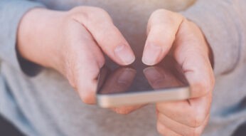 Auf dem Bild zum Thema Google Pixel Akku tauschen hält eine Person ein Smartphone mit beiden Händen im Querformat. Der Fokus liegt auf den Fingern, die präzise das Display bedienen. Die Nahaufnahme vermittelt eine ruhige, konzentrierte Stimmung und steht symbolisch für technische Handgriffe oder Reparaturvorgänge am Gerät.