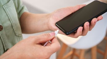 Das Bild im Artikel zum Akku wechseln beim Samsung zeigt, wie eine Person ein USB-C-Ladekabel an ein schwarzes Smartphone anschließt – stellvertretend für einen Akkuwechsel oder einen Ladevorgang.