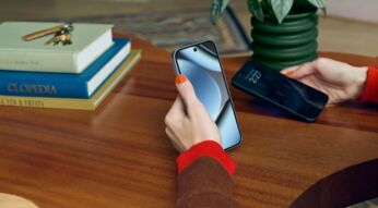 Eine Hand hält das Google Pixel 10 Pro, im Hintergrund ein dunkler Holzschreibtisch mit Büchern.