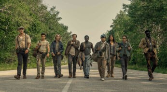 Mehrere junge Männer gehen in einer Reihe eine Straße entlang.