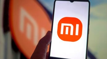Hand hält ein Xiaomi-Smartphone mit dem Schriftzug "Mi" auf dem Display