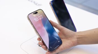 Hand hält im Apple Store ein iPhone 16 Pro in die Kamera.