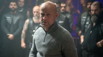 Jürgen Vogels Robert steht mit dem Rücken vor den Männern eines Motorradclubs.