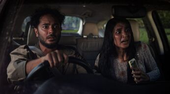 Ein Mann und eine Frau starren geschockt aus dem Auto heraus.