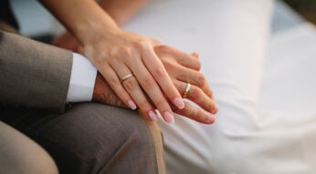 Auf dem Bild in dem Artikel zu Hochzeit auf den ersten Blick 2025 sind zwei Hände zu sehen. Beide tragen goldene Eheringe.