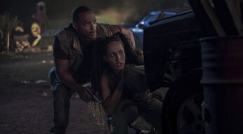 Anthony Mackie und Tiana Okoye hocken in einer "Twisted Metal"-Szene hinter einem Auto.