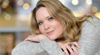 Auf dem Bild zur Crescent City-Reihenfolge ist die Autorin Sarah J. Maas in einem ruhigen Porträt zu sehen. Sie lehnt entspannt an einer Brüstung, trägt einen hellen Strickpullover und einen auffälligen Ring. Ihr freundlicher Blick und das weiche Bokeh im Hintergrund erzeugen eine warme, inspirierende Stimmung, die Kreativität und literarische Nähe vermittelt.