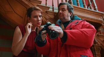 In den Streaming-Highlights im Februar 2026 ist eine Szene aus „Fabian und Die mörderische Hochzeit“ zu sehen. Zu sehen ist Bastian Pastewka, der in einer roten Jacke eine Kamera prüft, während eine Frau neben ihm gespannt hinschaut.