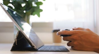 Eine Person spielt mit einem Controller an einem Tablet.