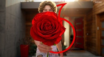 Eine Person hält eine Rose in die Kamera