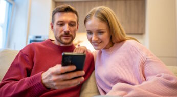 Ein Paar schaut zusammen auf ein Smartphone