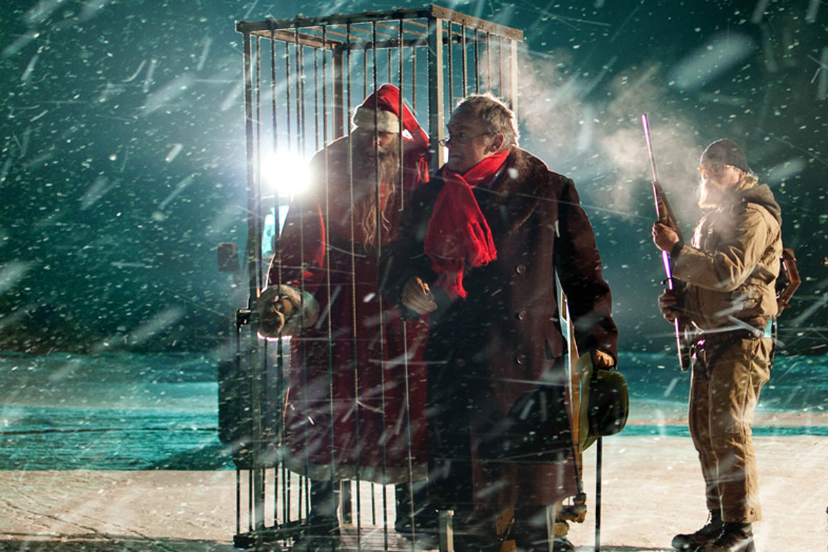 Auf dem Bild sieht man bewaffnete Männer und den Weihnachtsmann in einem Käfig