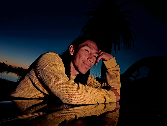 Das Bild zeigt einen Mann, der nachts ein Foto aufnimmt und die Nachtsicht-Funktion der Kamera vorfhrt