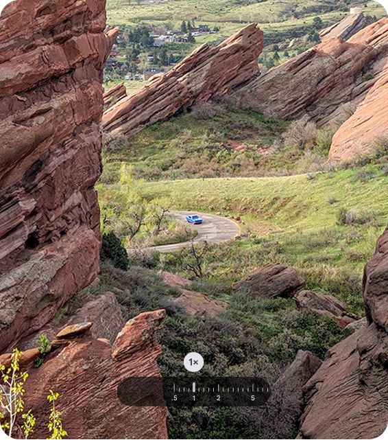 Eine Panorama-Auenaufnahme zeigt ein blaues Auto auf einer kurvenreichen Strae