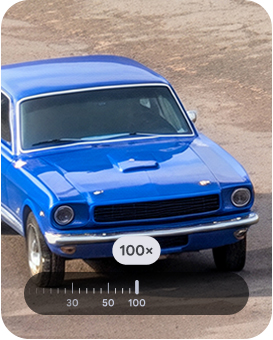 Eine stark vergrerte Ansicht eines leuchtend blauen Oldtimers, der auf einer Kiesoberflche geparkt ist und die Leistungsfhigkeit des Super-Resolution-Zooms auf dem Pixel zeigt