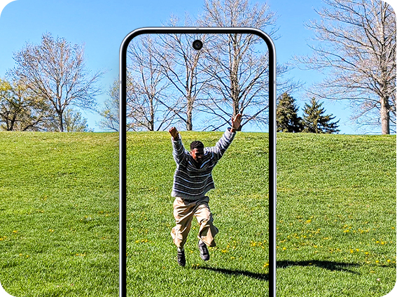 Ein Mann springt freudig in einem grasbewachsenen Park, aufgenommen mit einem Pixel-Smartphone