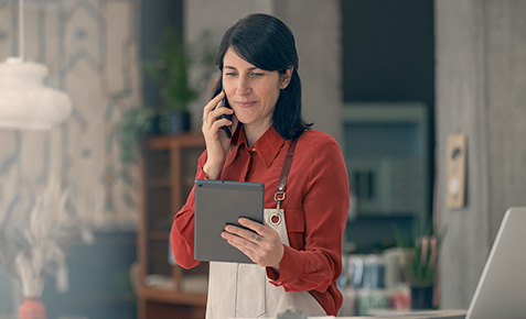 Frau mit Smartphone am Arbeitsplatz.