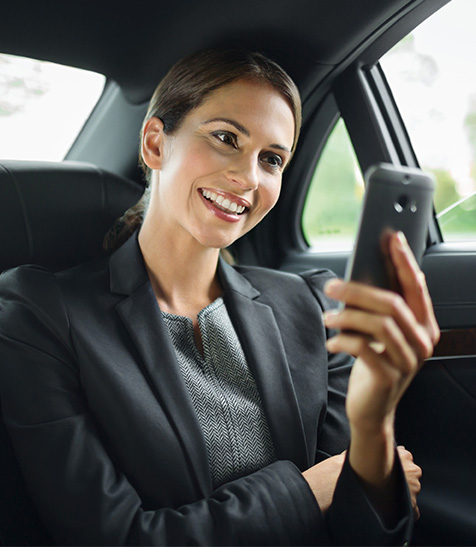 Business-Frau nutzt im Auto ihr Smartphone mit 4G|LTE in einem zuverlässigen Netz.